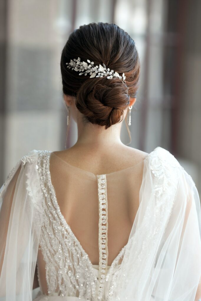 Bride in wedding dress from behind with glam bun hairstyle outdoors
