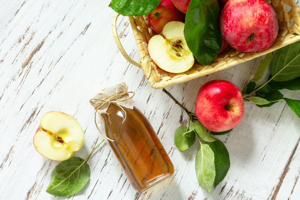 Healthy organic food. Apple vinegar, a bottle of apple cider vinegar on a rustic table.