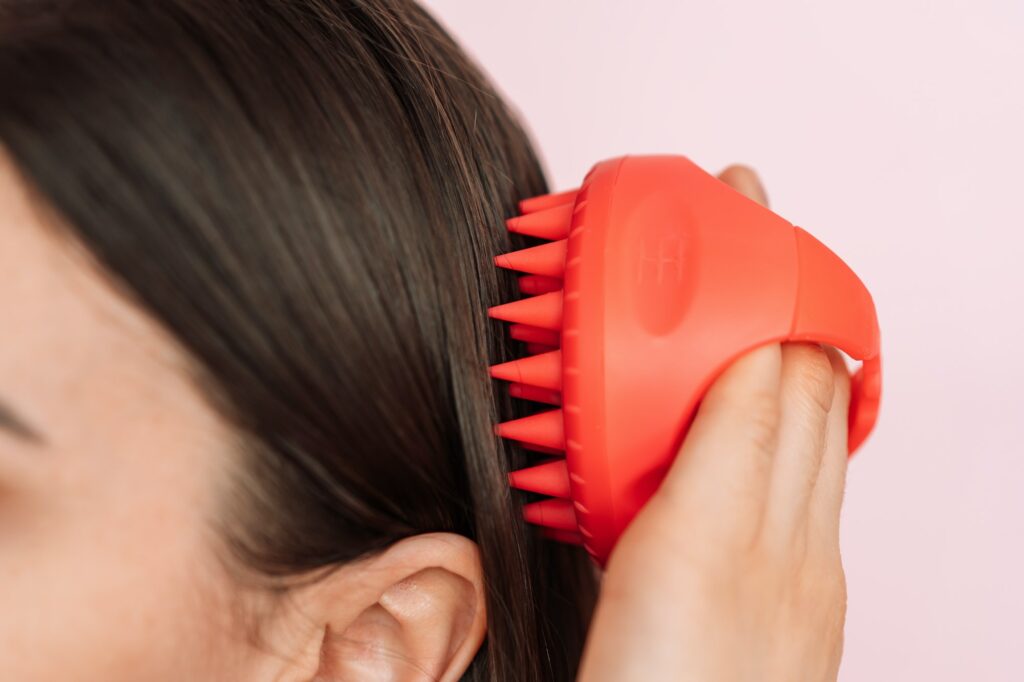 Lady taking care of hair and scalp with scalp massager