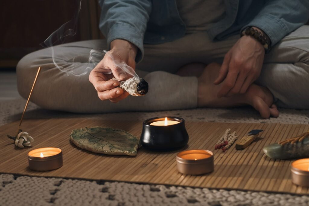 what is mind yoga? Man lighting incense for meditation and spiritual practice