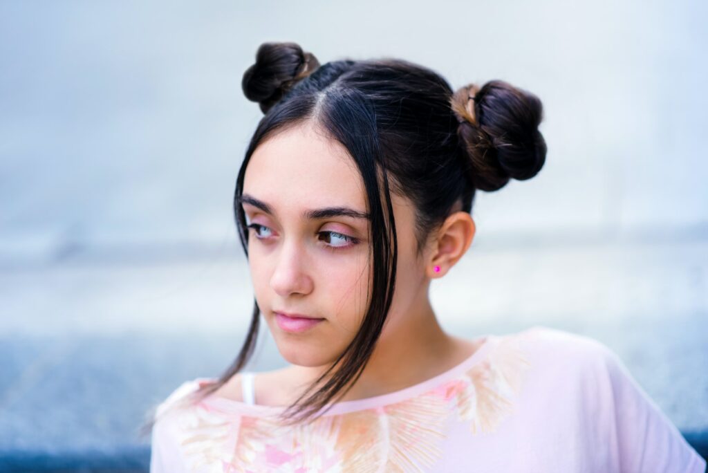 Teen girl with hair buns looking away