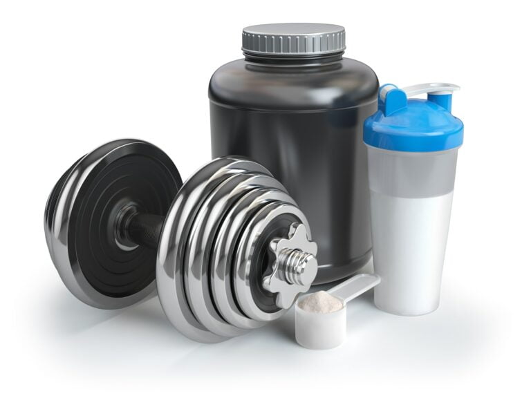 Whey protein powder in scoop with shaker and dumbbell. Bodybuil